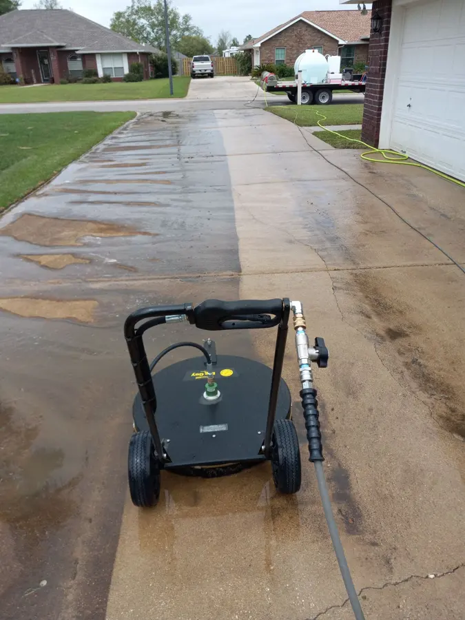 Wet concrete driveway with a surface cleaner